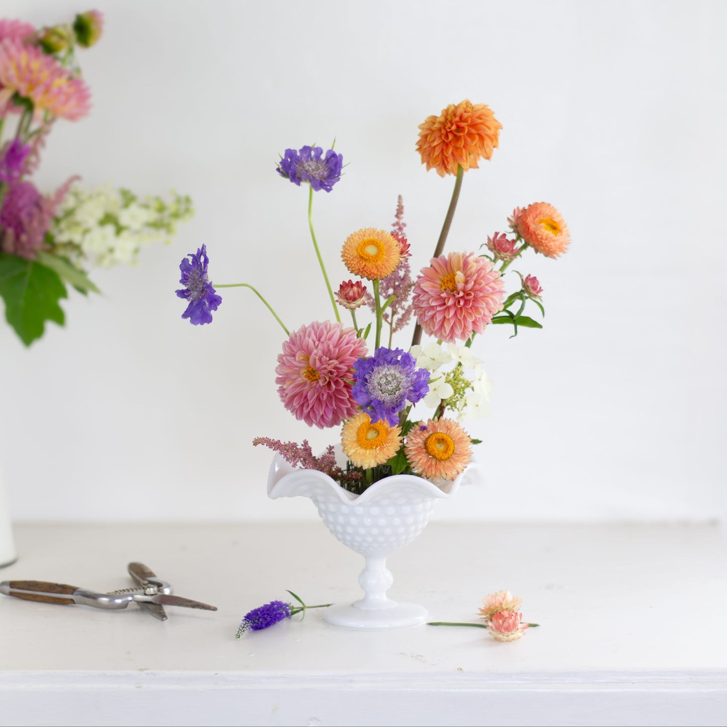 Small hairpin holder kenzan flower frog with flowers in a white footed vase. Made exclusively by Floral Genius