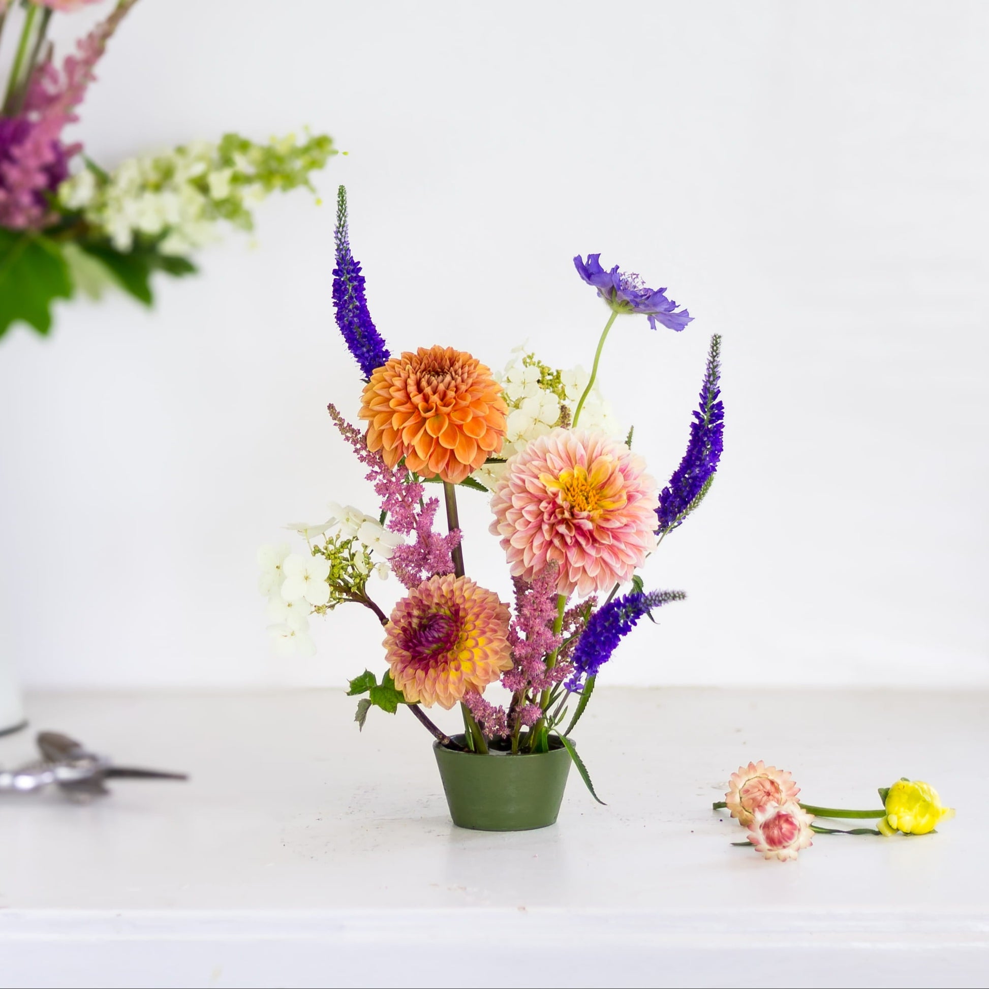 Small tapered pin cup flower frog kenzan with flowers made by Floral Genius